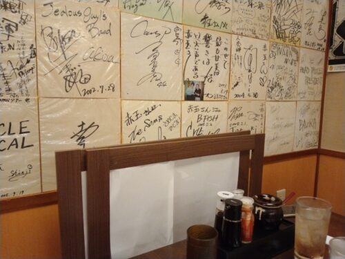 壁に貼られたたくさんの芸能人のサイン